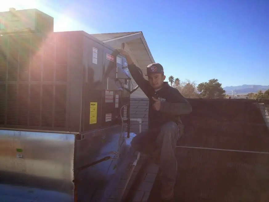 HVAC technician performing HVAC Inspection on a rooftop unit in Perryville